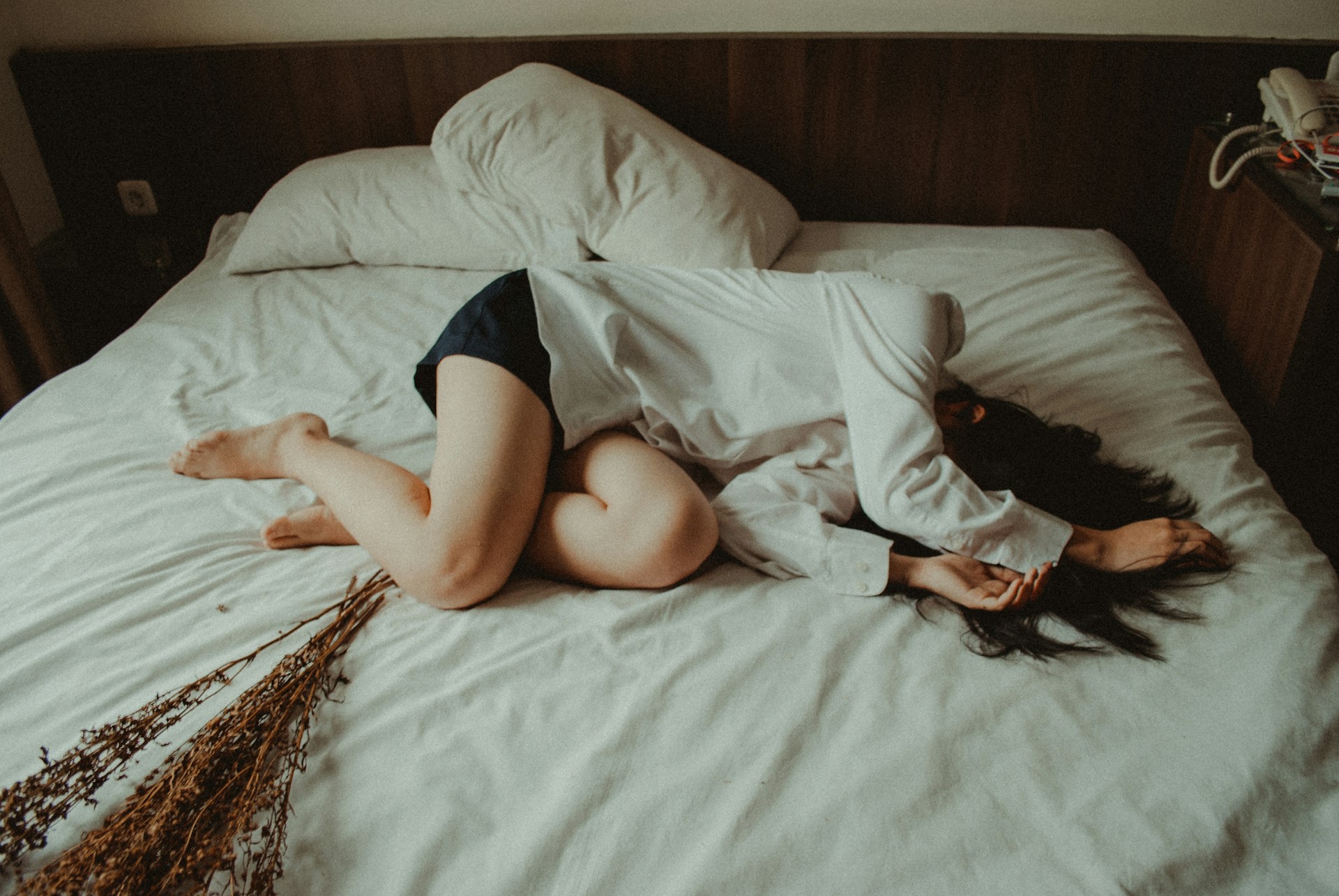 A woman lying in bed feeling sick